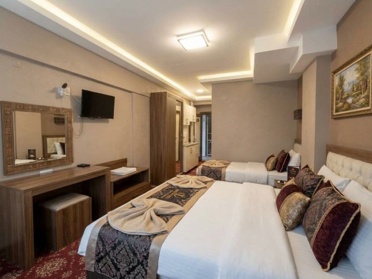 A hotel room with a bed, a desk, a television, and a mirror.