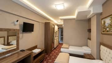 A hotel room with a bed, a desk, a mirror, a television, and a painting on the wall.