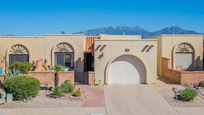 A two-story building with a garage door, arched windows, and a satellite dish. - Green Valley Casita - View ! (Green Valley)
