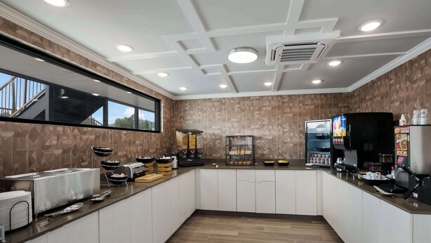 Una cocina moderna con una isla central, electrodomésticos integrados y un ventanal grande.