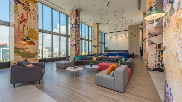 A spacious lounge with large windows, a modern sofa set, and a unique wall art installation. - PRESTIGE PENTHOUSE W OCEAN VIEW BRICKELL (Miami)