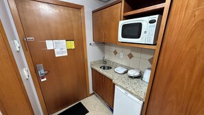 A compact kitchen with a microwave, a sink, and a small refrigerator.