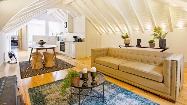 Un loft espacioso con cocina integrada, una zona de estar acogedora y una mesa de comedor.