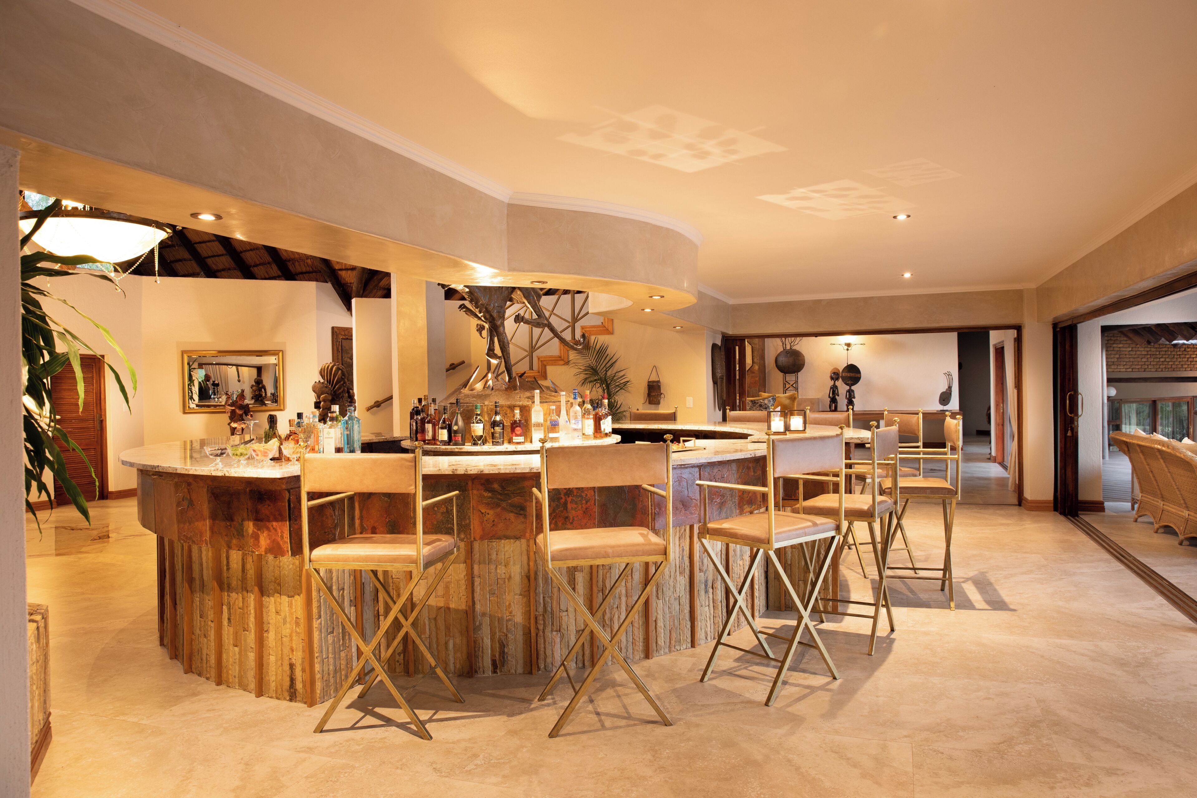 A bar area with wooden bar counter and multiple bar stools.