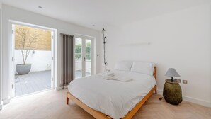Une chambre à coucher moderne avec un lit en bois, une grande fenêtre et une plante en pot.