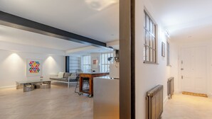 Un vaste espace de vie au design moderne, comprenant une grande table en verre, un canapé et une table à manger.