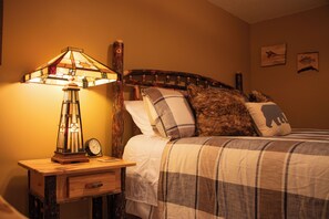 A bedroom with a bed, a nightstand, a lamp, and a clock. - Welcome to Dells Escape: A Historic Getaway on Dells Mill Pond (Augusta)