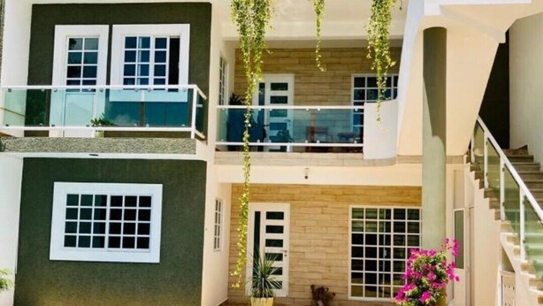 Un immeuble résidentiel à plusieurs étages doté d’une piscine, de balcons et de plantes en pot.
