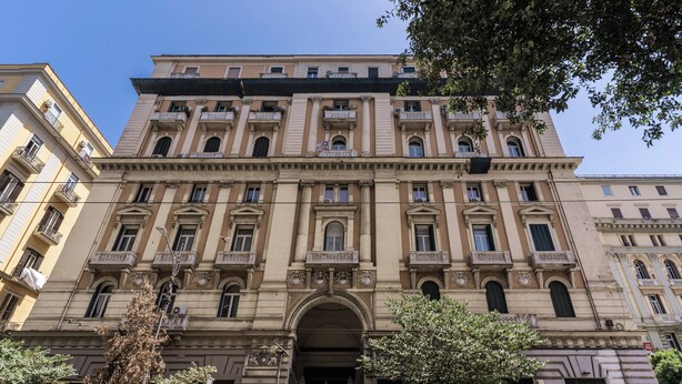 Un edificio de varios pisos con arquitectura clásica, que cuenta con una entrada central con un arco y varios balcones.