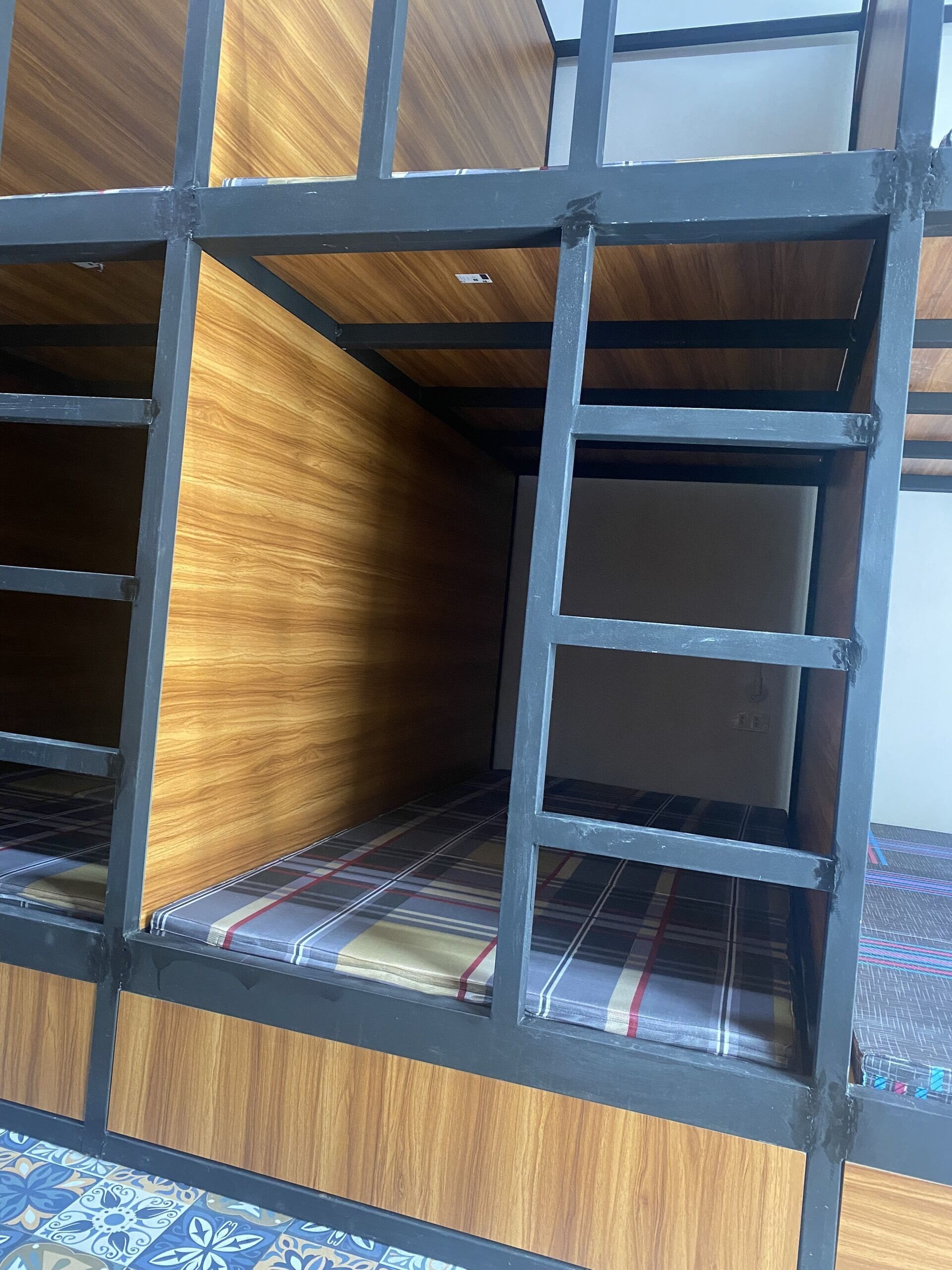 Een stapelbed met een houten hoofdbord en een metalen frame.