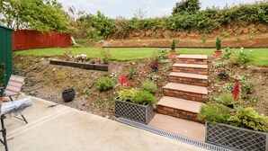 A garden with a brick pathway, raised beds, and a variety of plants. - Ahiohill Meadows (Aghyoghil Beg)