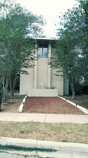 Stylish building surrounded by a beautifully maintained garden with lush trees and shrubs.