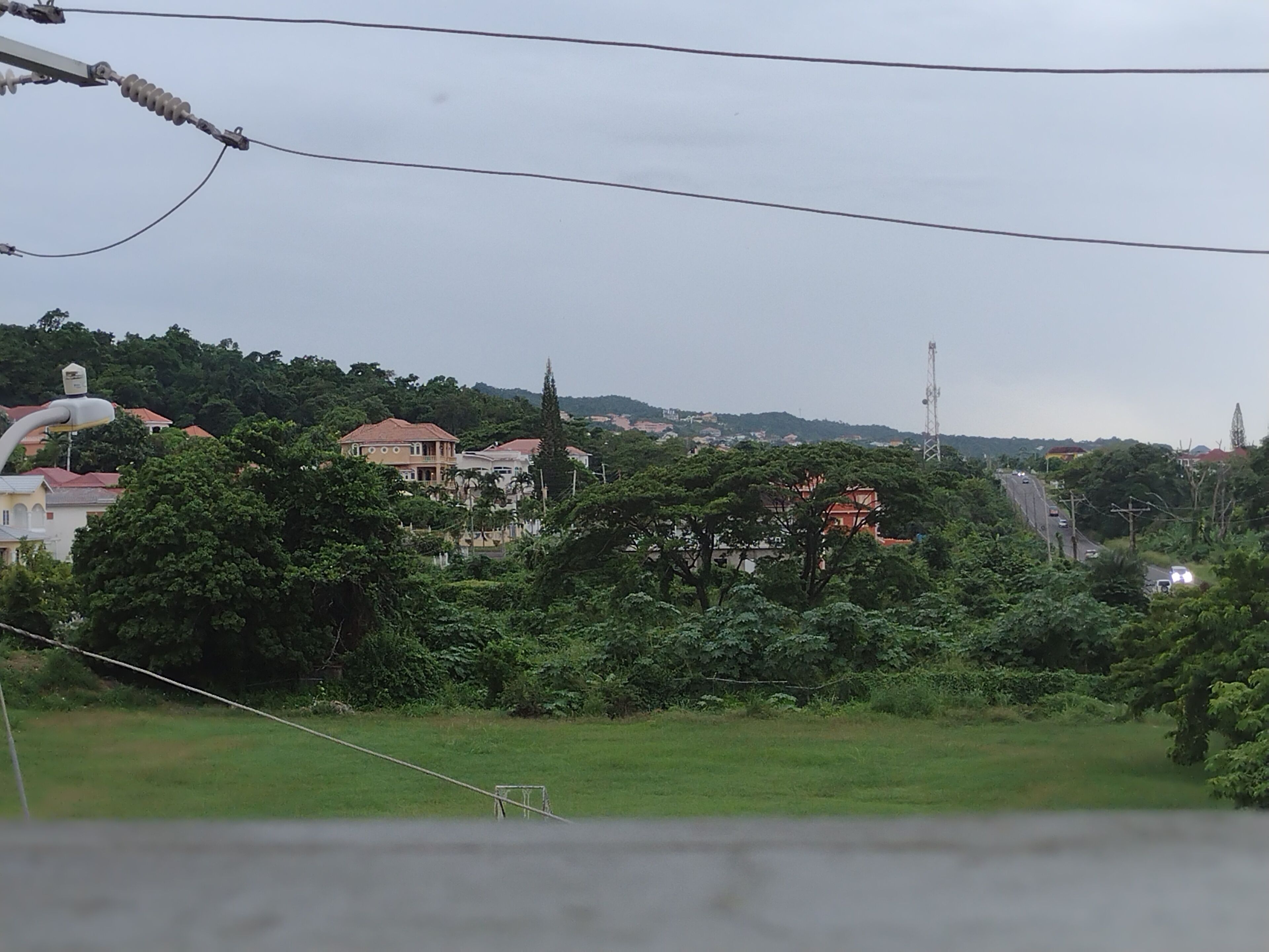 A residential area with houses, greenery, and a road.