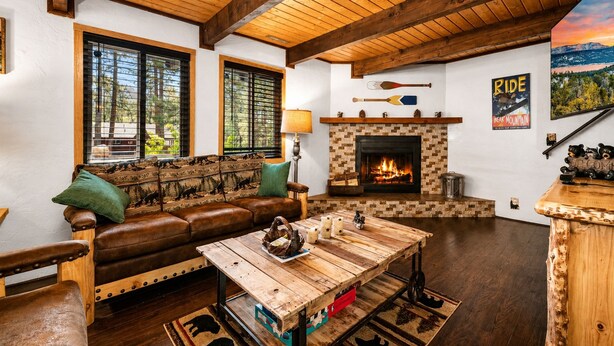 Una sala de estar acogedora con chimenea, muebles de madera y una vista panorámica.