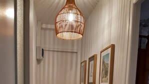A hallway with a wooden door, a radiator, and framed pictures on the wall.