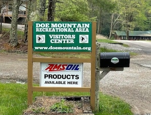 A sign for Doe Mountain Recreational Area Visitors Center with a mailbox and AMSOIL products available. - Forest Getaway (Mountain City)