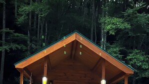A wooden cabin with a porch, two windows, and a door. - Forest Getaway (Mountain City)