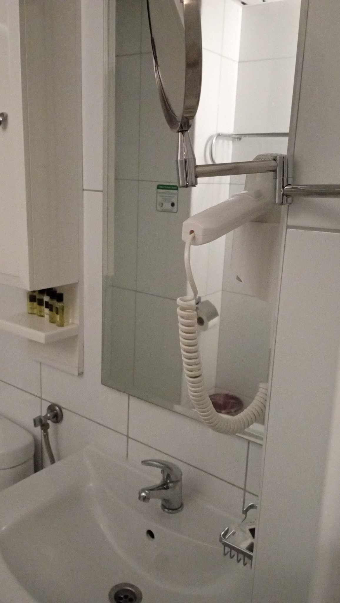 A bathroom with a sink, mirror, and towel rack.