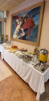 Una mesa de buffet con diferentes comidas y un cuadro en la pared.