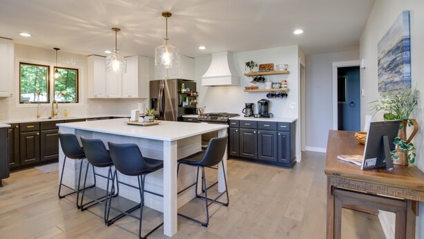 A modern kitchen with a central island, bar stools, pendant lighting, and built-in appliances. - Lakefront Sunburg Vacation Rental w/ Boat Dock! (Sunburg)