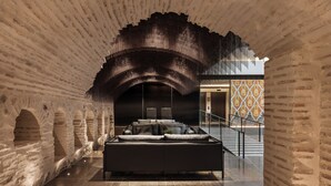 A modern interior with a brick wall, a sofa, and a staircase. - Áurea Toledo (Toledo)