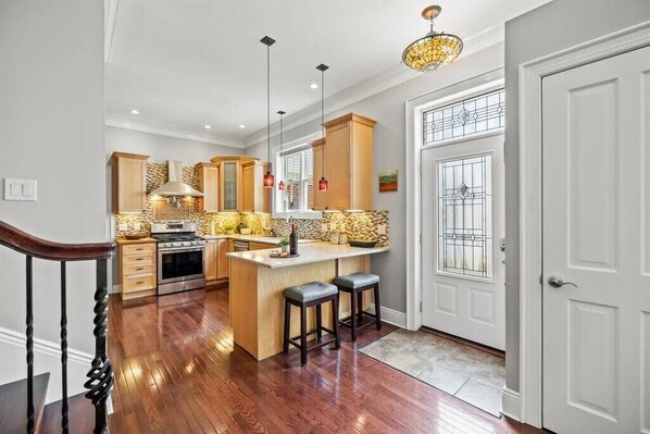 Functional kitchen with a central island, contemporary cabinetry, and stainless steel range.