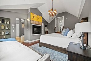 Relax in this stylish bedroom with a large bed, fireplace, and cozy seating area.