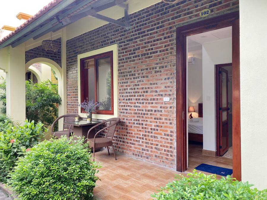 A brick exterior with a door, a window, and a small patio area with a table and chairs.