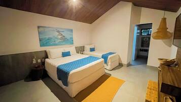A bedroom with two beds, a ceiling fan, a painting, and a bathroom visible through an open door.