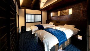 A hotel room with two beds, a large window, and a dark wooden ceiling. - Tikkan Tsuyukusa-An (Kyoto)