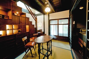 A traditional Japanese room with tatami flooring, a low table, and a wooden chair. - Tikkan Tsuyukusa-An (Kyoto)