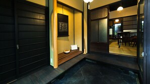 A traditional Japanese interior with tatami flooring, sliding doors, and a reception area with a reception desk and chairs. - Tikkan Tsuyukusa-An (Kyoto)