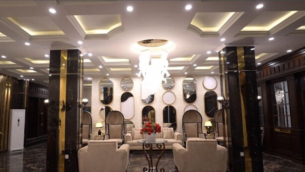A lobby with a chandelier, seating area, and decorative mirrors. - Hotel Heaven Heights (Islamabad)
