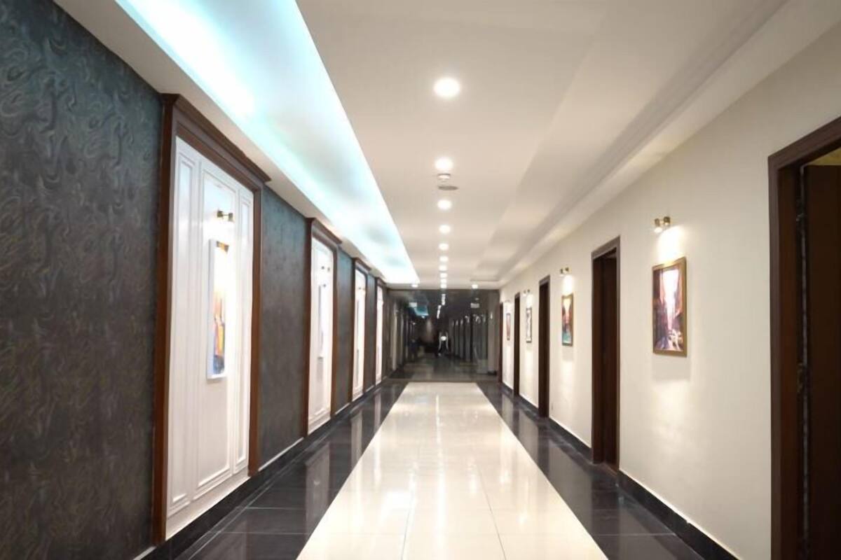 A long, well-lit hallway with doors on both sides, leading to rooms.