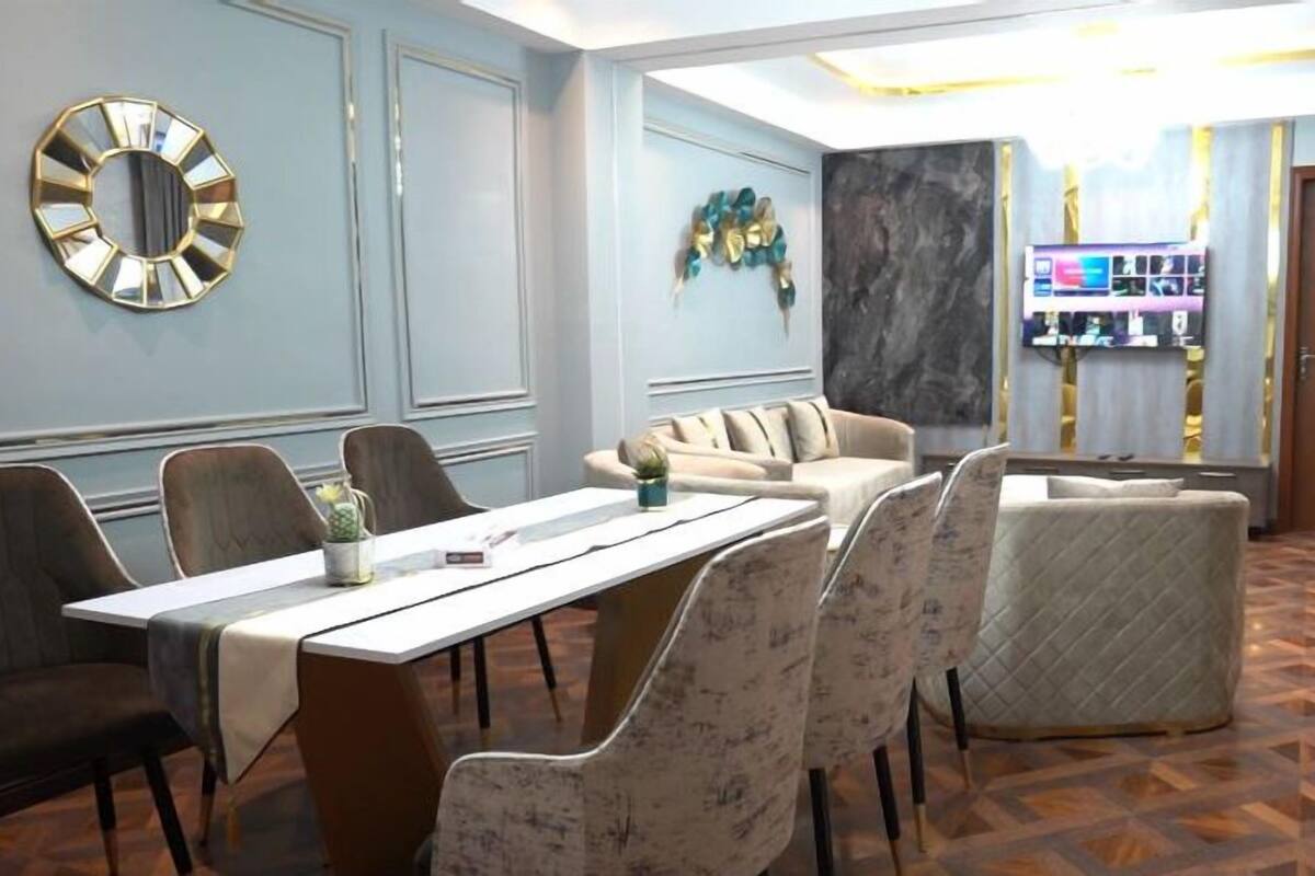 A modern conference room with a long table, comfortable seating, and a decorative wall piece.