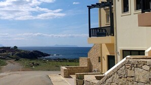 A coastal building with a stone facade, a balcony, and a view of the sea. - Nina's Place, 5min On Foot From The Beach (Mylopotamos)