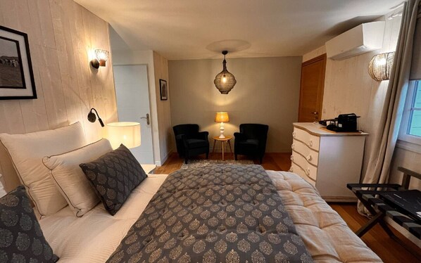 A bedroom with a bed, two chairs, a desk, and a lamp. - Chambre D'hôtes - Gary Player (AIX EN ISSART)