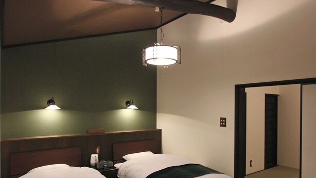 A hotel room with two beds, a nightstand, a lamp, and a mirror. - Kiyomizu Birodo-An (Kyoto)