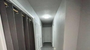 A narrow hallway with a carpeted floor, leading to a door at the end. - Charming Downtown Home on 5th street (Midlothian)