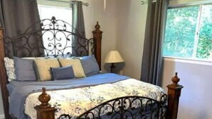 A bedroom with a bed, a ceiling fan, a window, and a rug. - Charming Downtown Home on 5th street (Midlothian)
