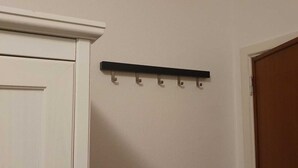 A white door with a black coat hook mounted on the wall. - Room-cosy Room In Antwerpen (Mortsel)