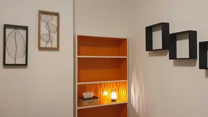 A room with a white wall, a framed leaf artwork, a tissue box, and three black square shelves. - Room-cosy Room In Antwerpen (Mortsel)
