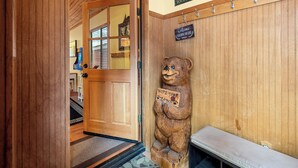 A wooden door with a sign reading "WELCOME" and a bear statue holding a sign that says "WIFE YOUR PAWS". - Moonridge Heaven (Big Bear Lake)