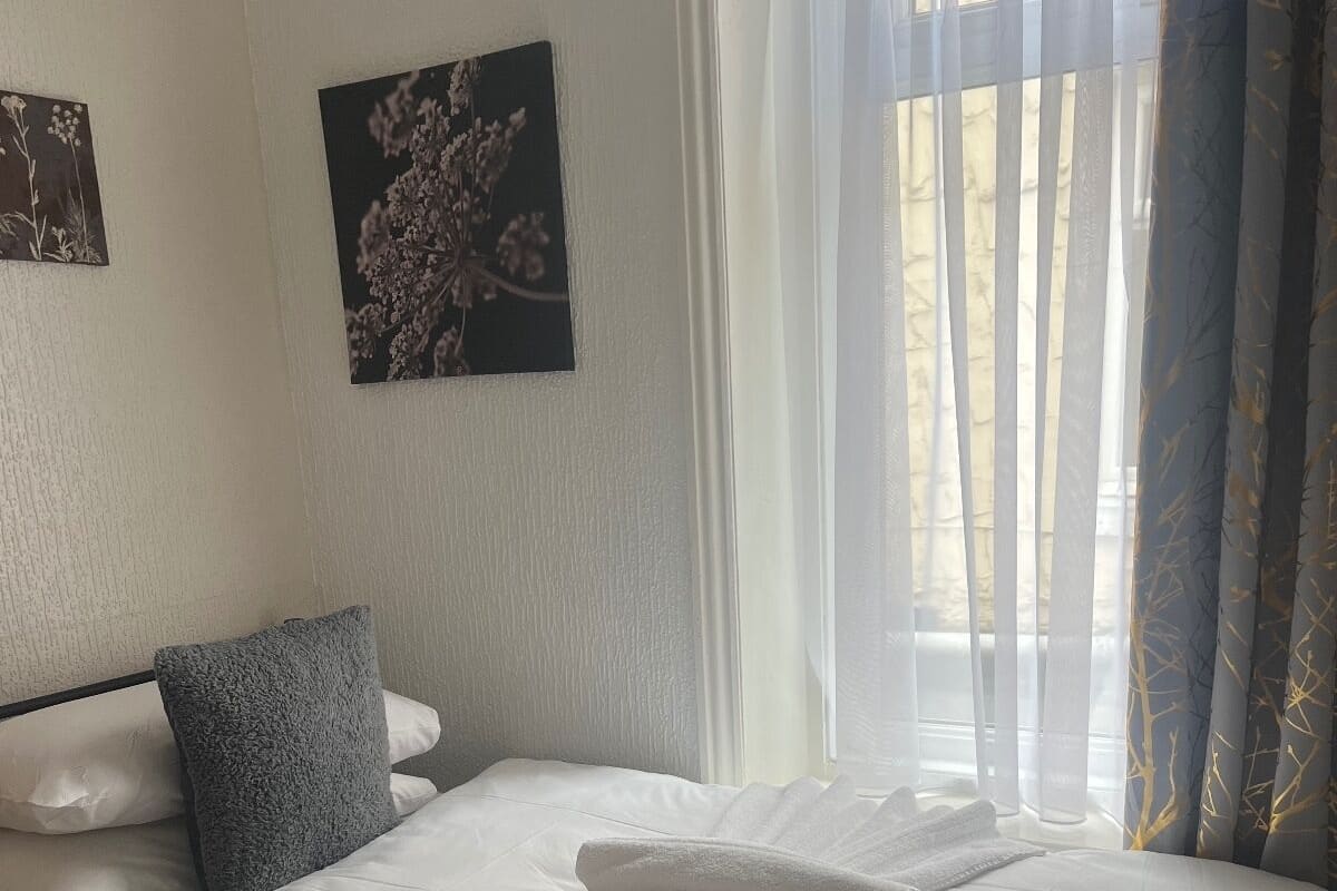 Eenpersoonskamer | Een strijkplank/strijkijzer, beddengoed