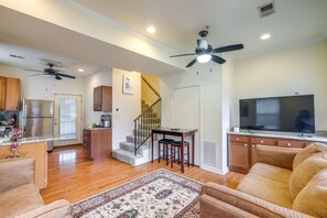 Cozy living area with plush sofa, modern kitchen, and dining space.