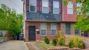 A two-story brick building with a black roof, red siding, and white-framed windows. - 5 Mi to US Capitol: Washington DC Townhome (Washington)