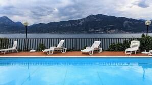 Une piscine avec des chaises longues et une vue sur les montagnes.