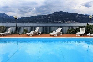 A swimming pool with lounge chairs and a view of mountains.