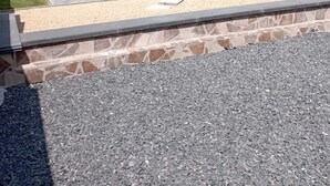 Un bâtiment en pierre avec un toit en tuiles, une petite fenêtre et une porte.