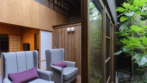 Un interior moderno con dos sillones grises y una pared de madera.